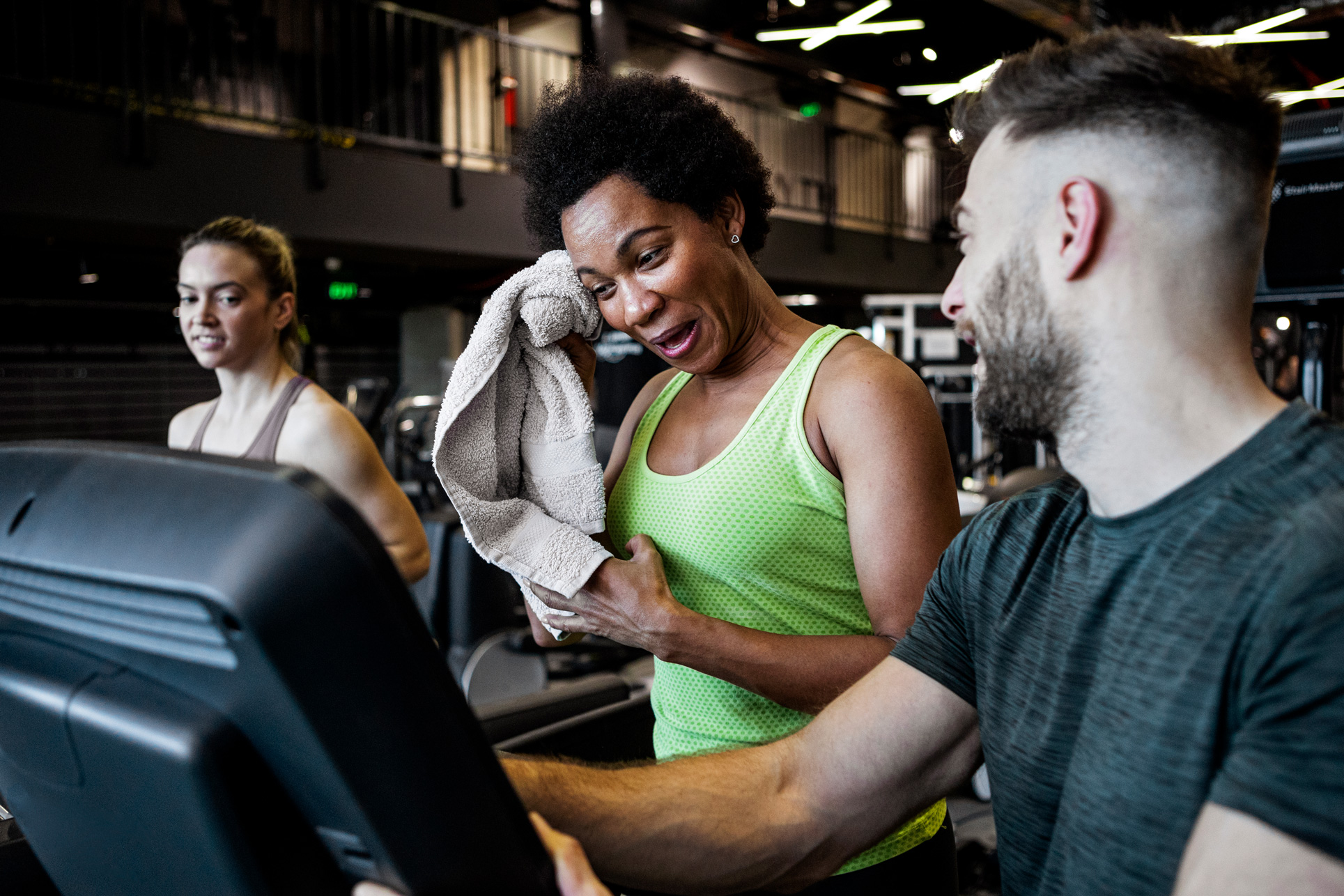 mixed-group-using-crosstrainers-in-gym-smiling-and-laughing mixed-group-using-crosstrainers-in-gym-smiling-and-laughing
